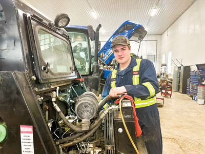 co-op student conducting maintenance on farm equipment