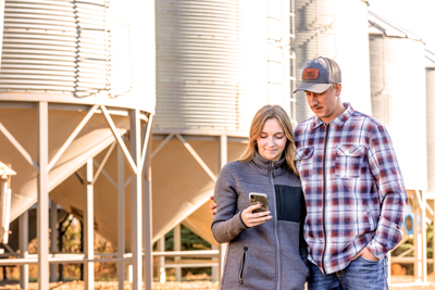 couple looking at mobile phone on farm