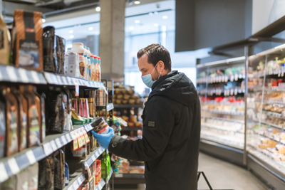 male looking at canned goods in grocery aisle