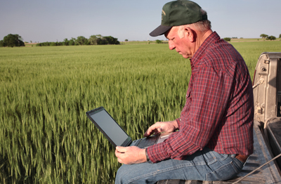 Farmer in Field using Laptop