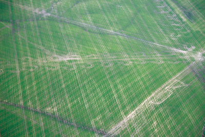 Aerial view of traffic marks in field made by equipment