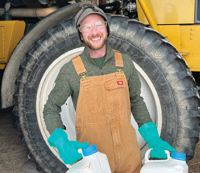 Farmer holding pesticide jugs