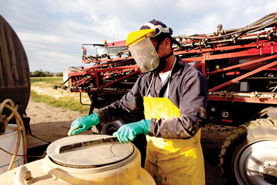 person in protective equipment handling chemicals