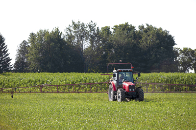 Tractor parked in front of crop field