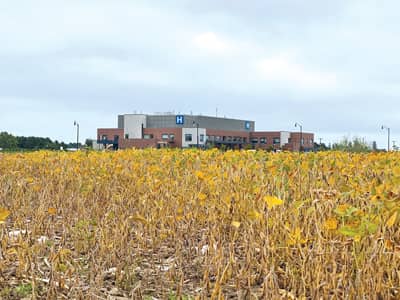 rural hospital behind a field of soybeans